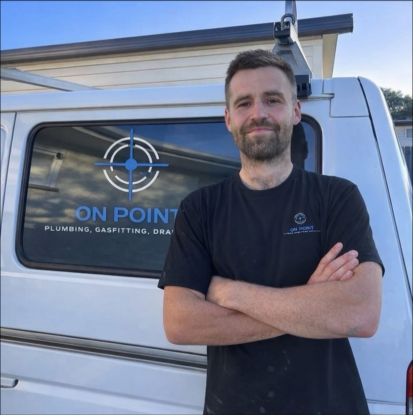 Mike Whitehead, owner and operator of On Point Plumbing Manawatu Ltd, standing by his branded work van